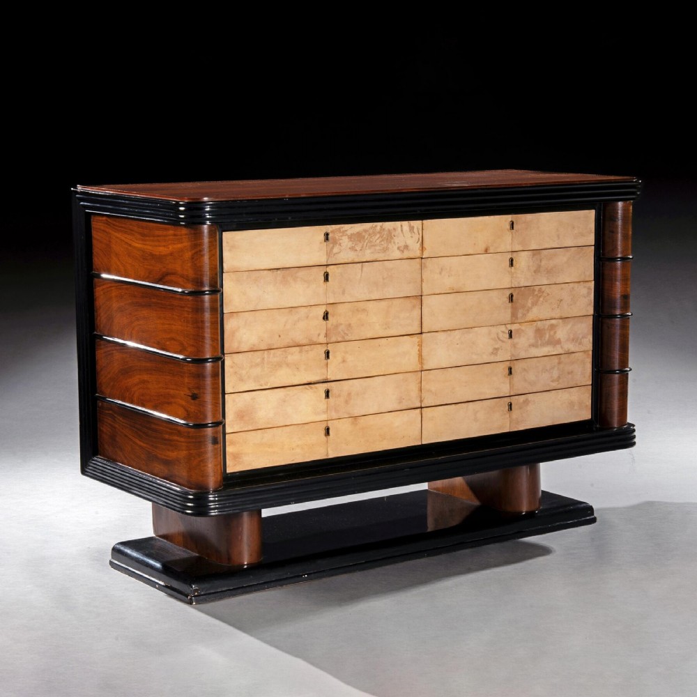 An Art Deco palisander commode featuring twelve parchment-covered drawer fronts, ebonised side trim, curved timber flanks, and a stepped plinth base.