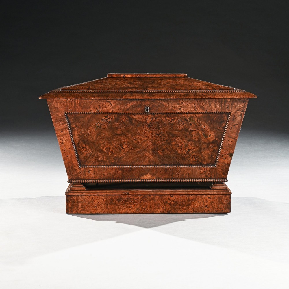 A George IV sarcophagus-shaped cellarette crafted from figured pollard oak with a stepped lid and beaded moulding on a plinth base. View III