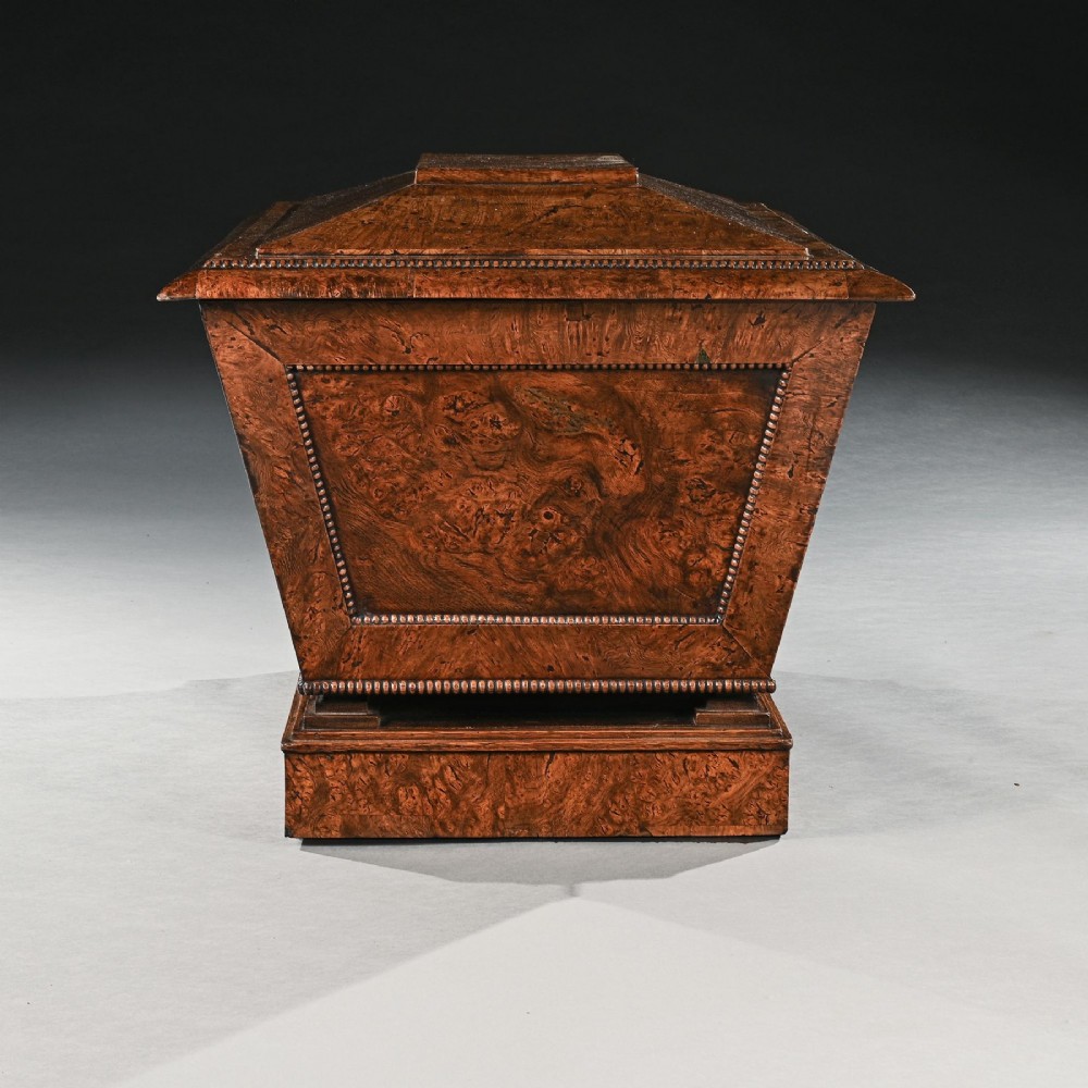 A George IV sarcophagus-shaped cellarette crafted from figured pollard oak with a stepped lid and beaded moulding on a plinth base. View V