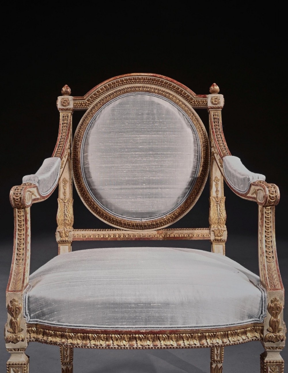A pair of 19th-century Italian Neoclassical armchairs featuring cream painted and gilt carved frames, oval backrests, and light grey silk upholstery. View VII