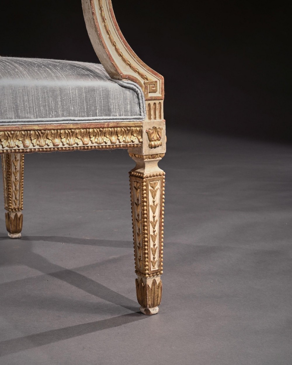 A pair of 19th-century Italian Neoclassical armchairs featuring cream painted and gilt carved frames, oval backrests, and light grey silk upholstery. View VIII
