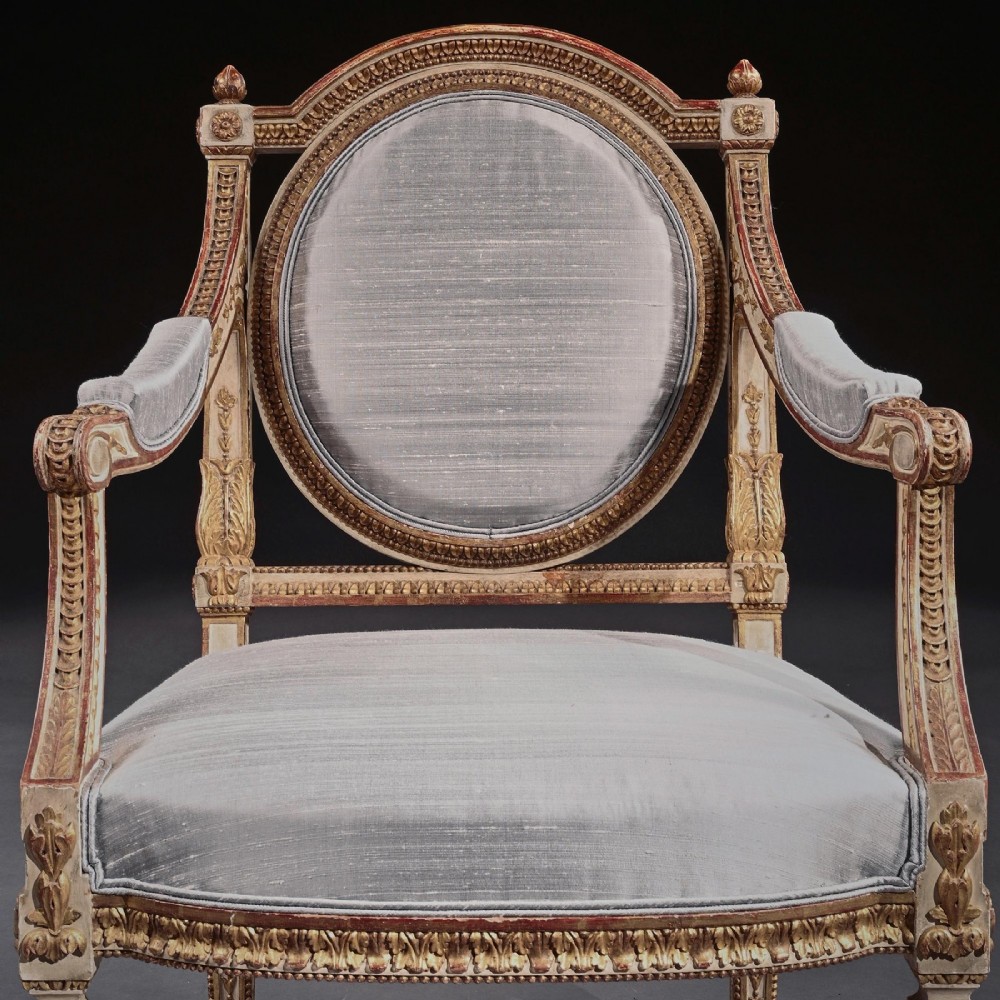 A pair of 19th-century Italian Neoclassical armchairs featuring cream painted and gilt carved frames, oval backrests, and light grey silk upholstery. View XII