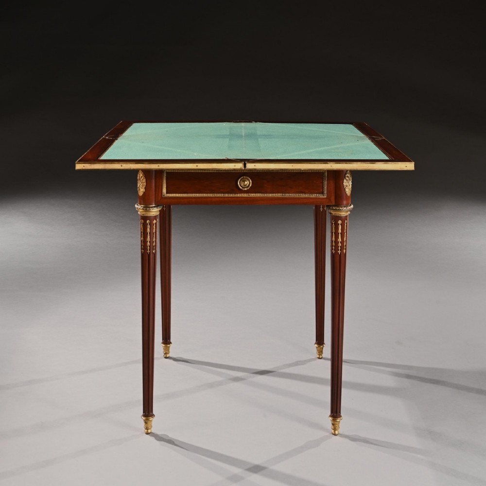 A square mahogany envelope card table with gilt bronze mounts, fluted tapered legs, and four triangular folding top flaps. View V