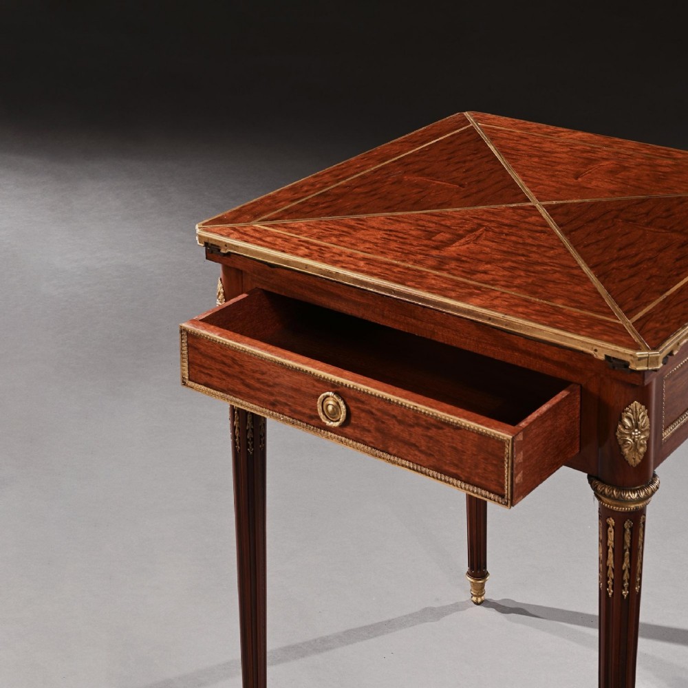 A square mahogany envelope card table with gilt bronze mounts, fluted tapered legs, and four triangular folding top flaps. View VII