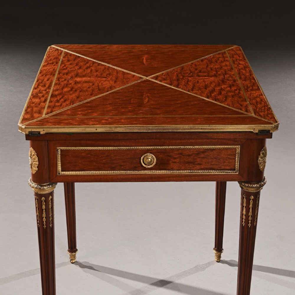 A square mahogany envelope card table with gilt bronze mounts, fluted tapered legs, and four triangular folding top flaps. View VIII
