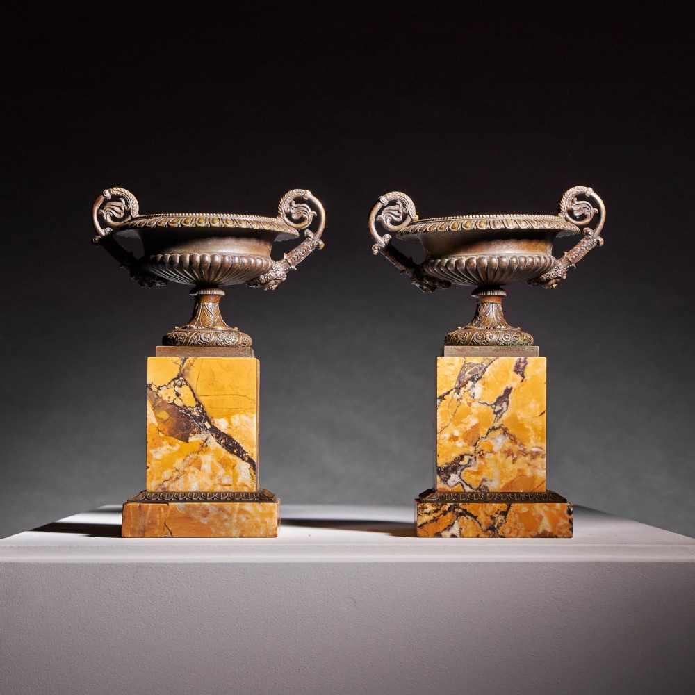 A pair of early nineteenth-century French patinated bronze tazzas with ornate scroll handles mounted on square veined yellow marble plinths. View III
