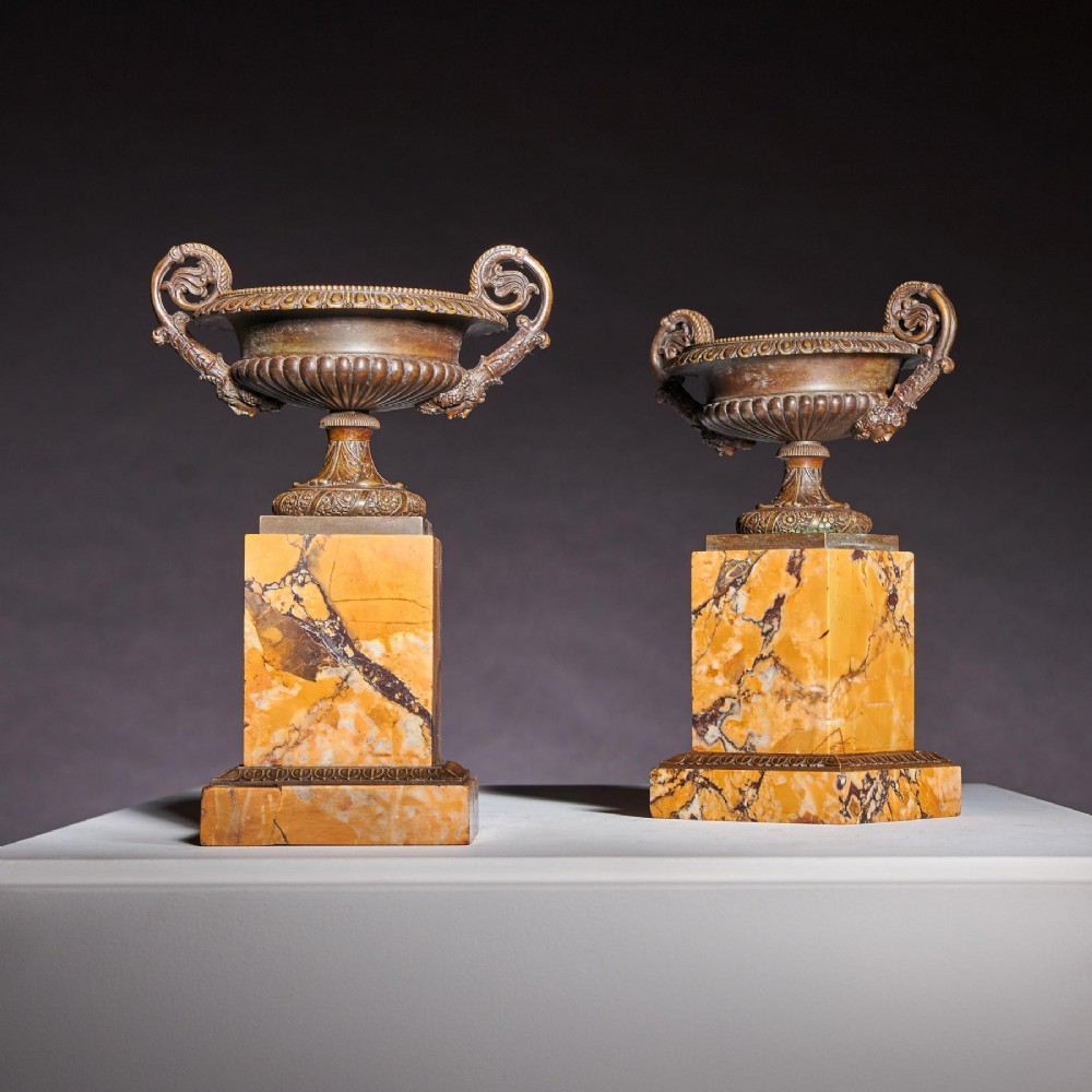 A pair of early nineteenth-century French patinated bronze tazzas with ornate scroll handles mounted on square veined yellow marble plinths. View IV