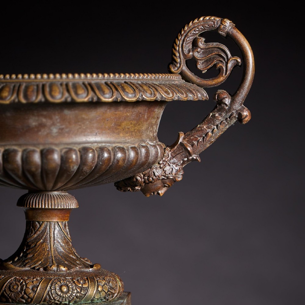 A pair of early nineteenth-century French patinated bronze tazzas with ornate scroll handles mounted on square veined yellow marble plinths. View V