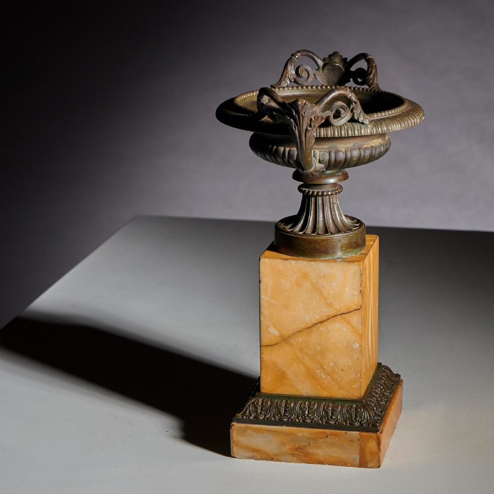 A pair of early 19th-century French Grand Tour bronze tazzas featuring fluted rims and scrolled handles set upon tall yellow Siena marble pedestal bases. View VI