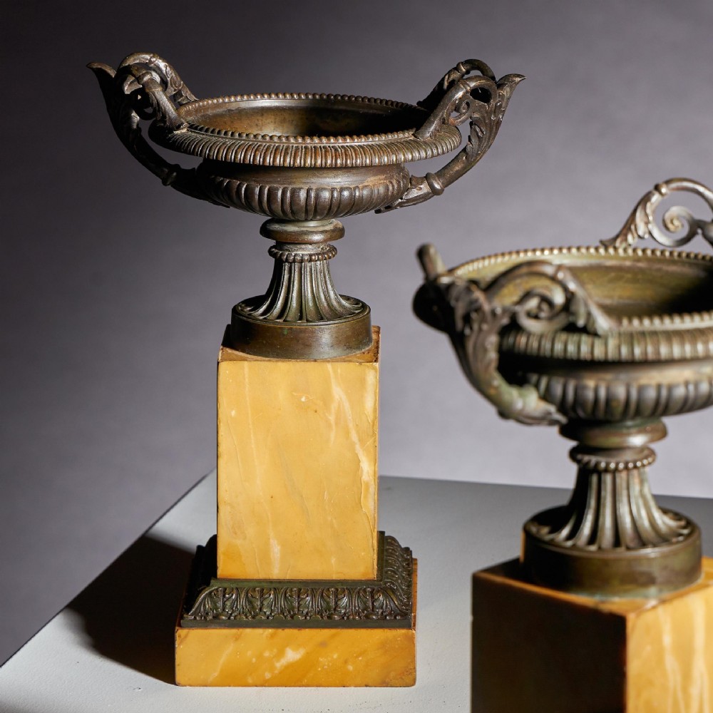 A pair of early 19th-century French Grand Tour bronze tazzas featuring fluted rims and scrolled handles set upon tall yellow Siena marble pedestal bases. View VIII