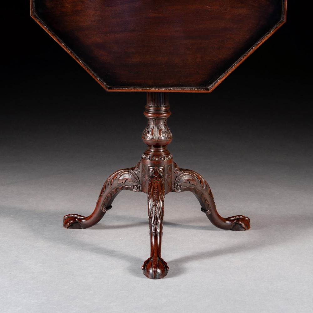 A George III dark mahogany octagonal tripod table featuring a pierced fretwork gallery top, fluted column, and carved legs with claw-and-ball feet. View III