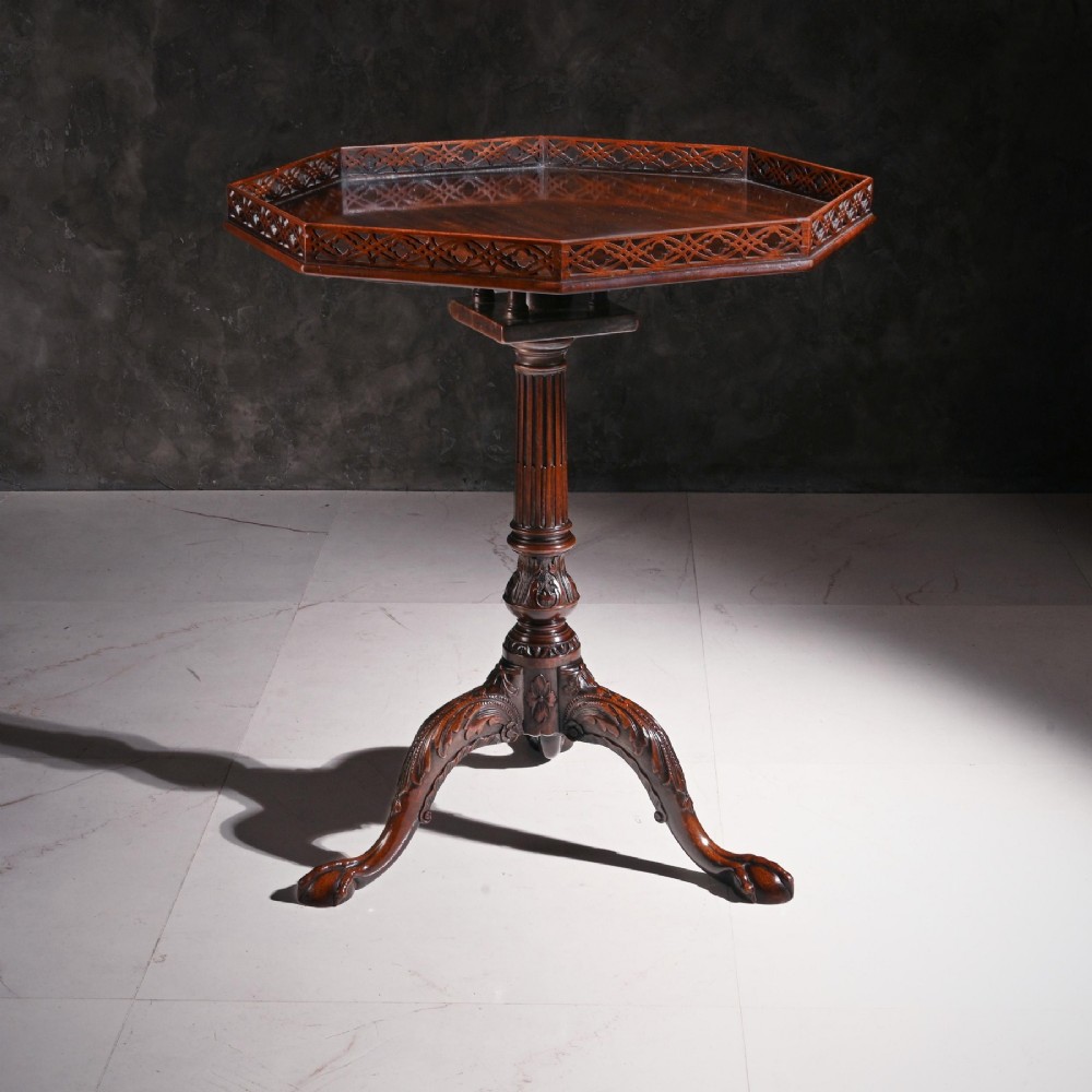A George III dark mahogany octagonal tripod table featuring a pierced fretwork gallery top, fluted column, and carved legs with claw-and-ball feet. View IV