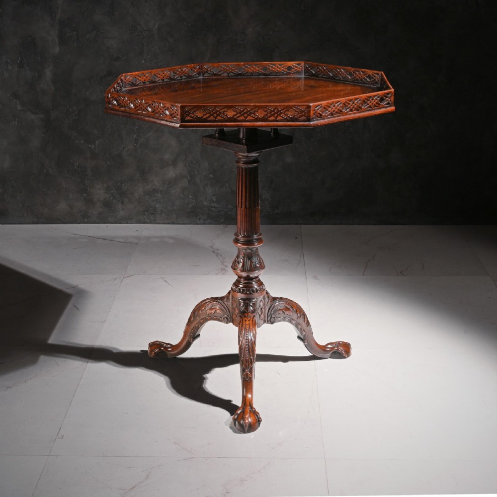 A George III dark mahogany octagonal tripod table featuring a pierced fretwork gallery top, fluted column, and carved legs with claw-and-ball feet. View V