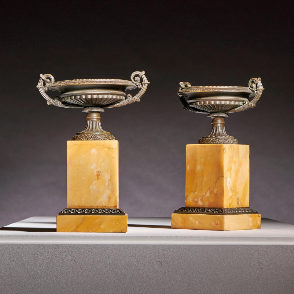 A pair of early 19th-century bronze tazzas with scroll handles mounted upon tall rectangular yellow Siena marble plinths. View II