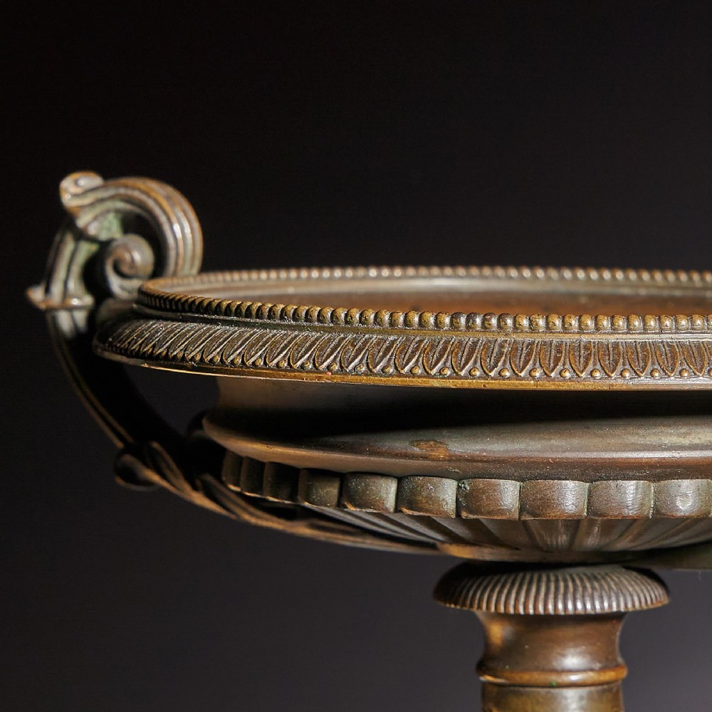 A pair of early 19th-century bronze tazzas with scroll handles mounted upon tall rectangular yellow Siena marble plinths. View V