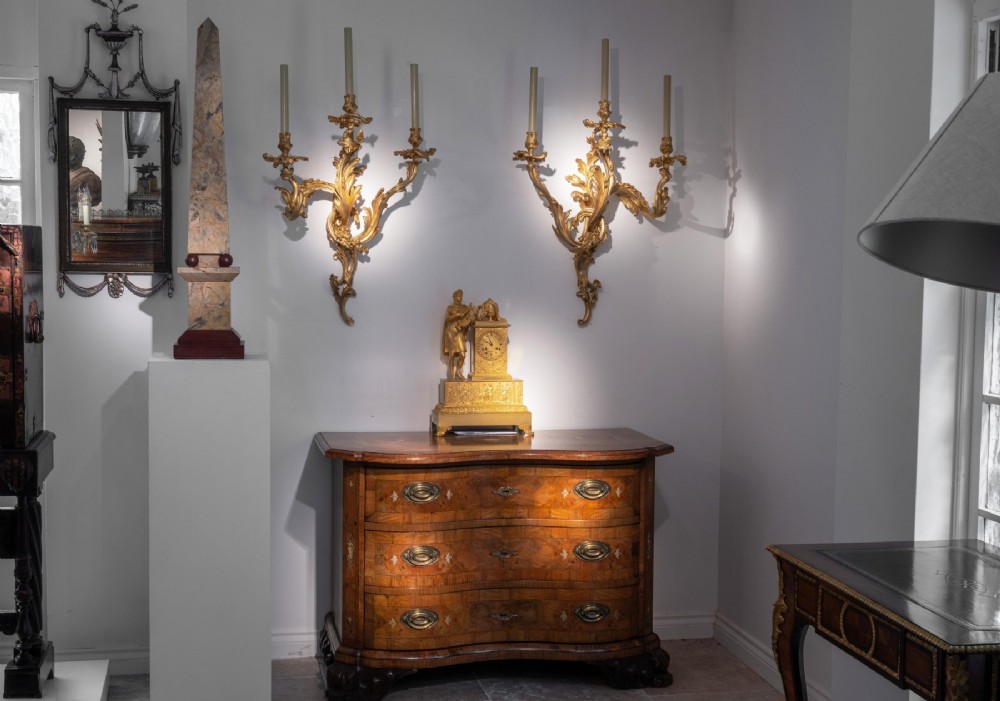 A set of three 19th-century Neoclassical wall mirrors featuring green painted and silvered frames topped with carved urn finials and drapery swags. View VII