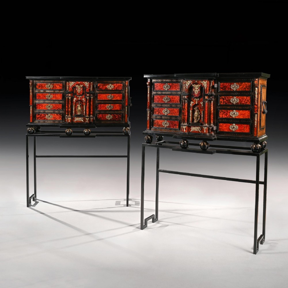 A pair of seventeenth-century Spanish Baroque ebonised and tortoiseshell cabinets featuring architectural central doors and gilt bronze mounts, elevated on tall metal stands. View II