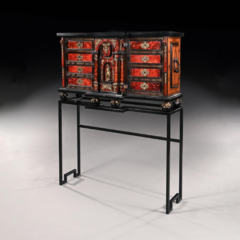 A pair of seventeenth-century Spanish Baroque ebonised and tortoiseshell cabinets featuring architectural central doors and gilt bronze mounts, elevated on tall metal stands. View III