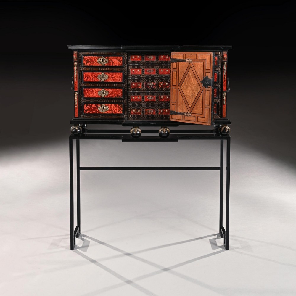 A pair of seventeenth-century Spanish Baroque ebonised and tortoiseshell cabinets featuring architectural central doors and gilt bronze mounts, elevated on tall metal stands. View IV
