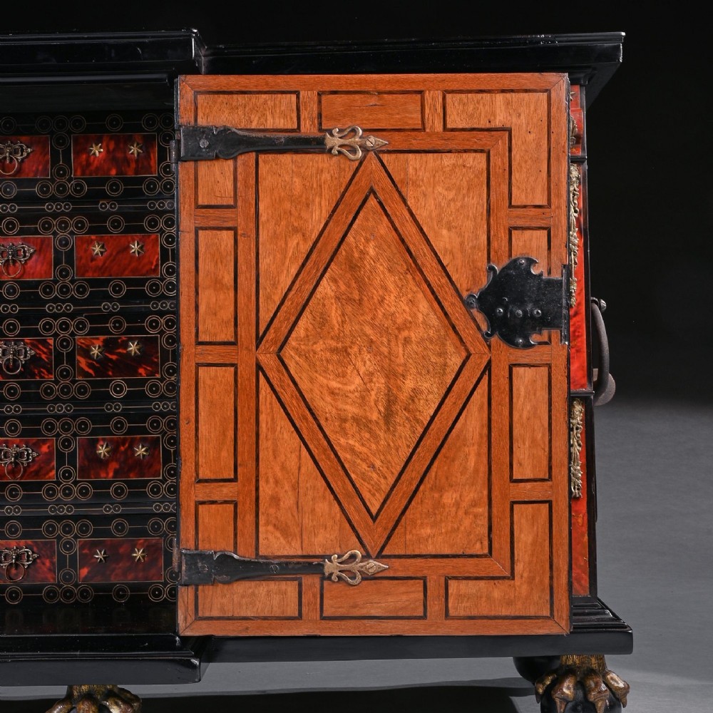 A pair of seventeenth-century Spanish Baroque ebonised and tortoiseshell cabinets featuring architectural central doors and gilt bronze mounts, elevated on tall metal stands. View X