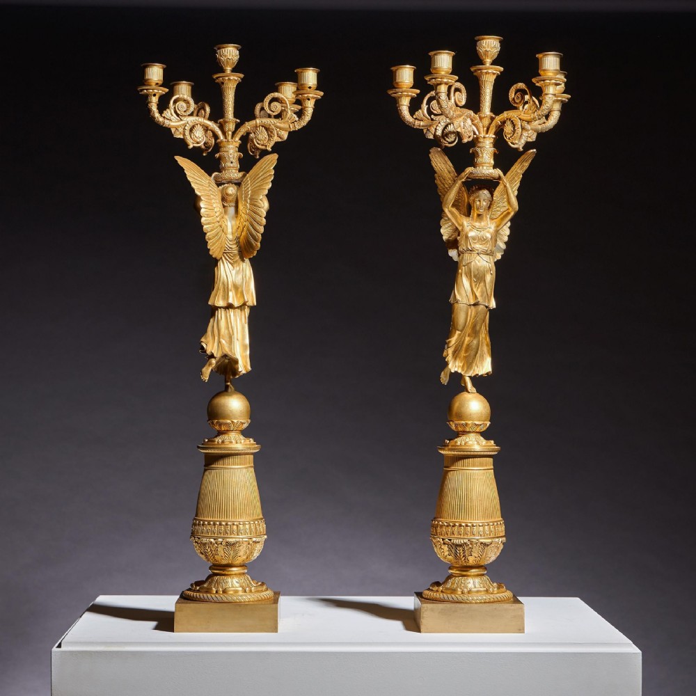 A pair of French Empire gilt bronze candelabra featuring winged Victory figures supporting multi-arm candle holders on pedestals. View III