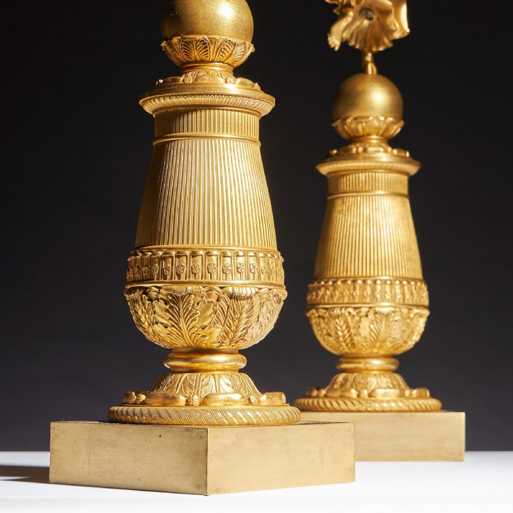 A pair of French Empire gilt bronze candelabra featuring winged Victory figures supporting multi-arm candle holders on pedestals. View IX
