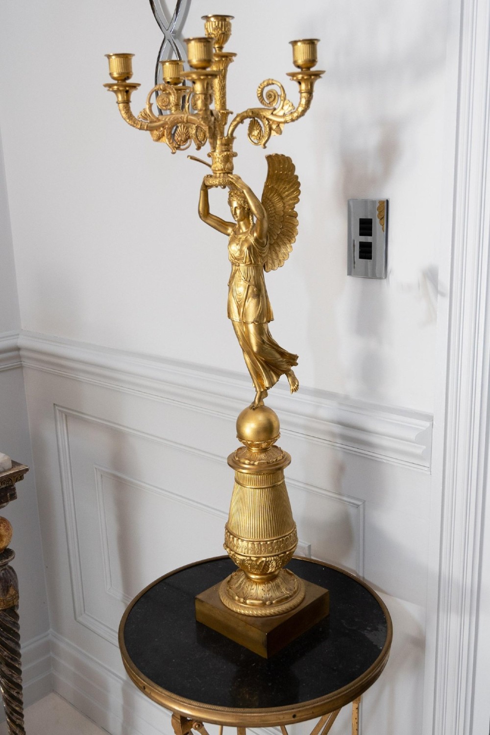 A pair of French Empire gilt bronze candelabra featuring winged Victory figures supporting multi-arm candle holders on pedestals. View XII