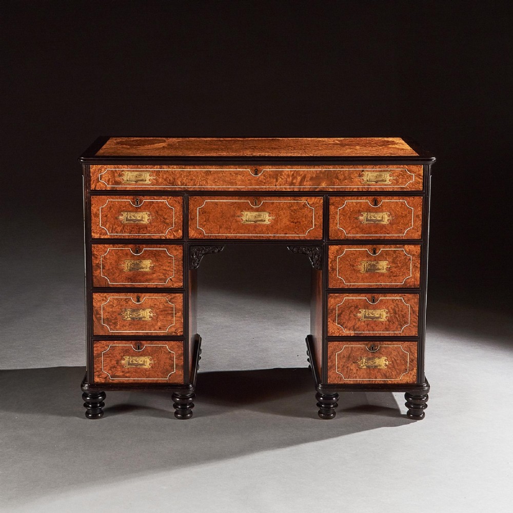 A 19th-century Chinese export kneehole campaign desk crafted from figured amboyna wood with ebony borders and brass carrying handles. View II