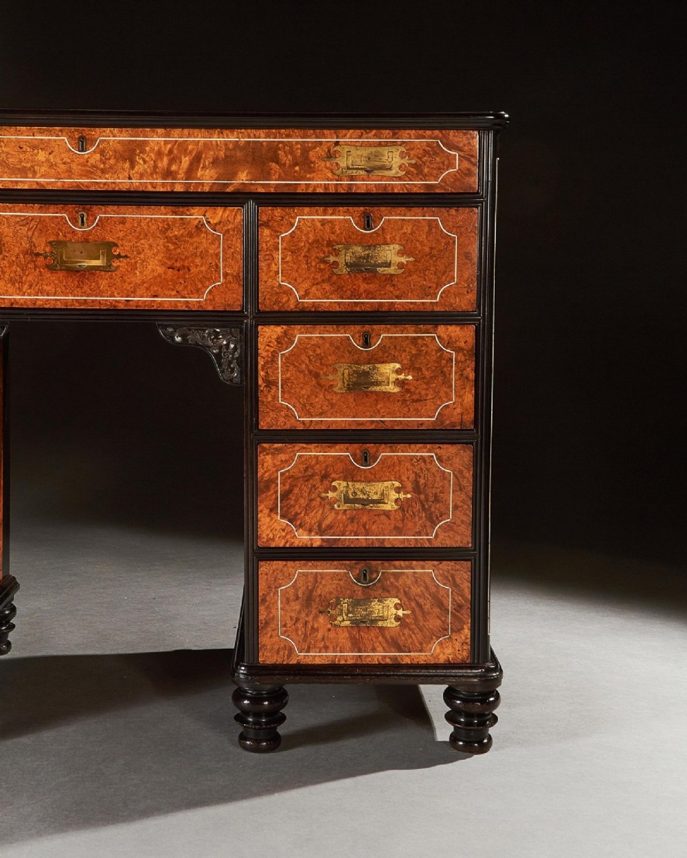 A 19th-century Chinese export kneehole campaign desk crafted from figured amboyna wood with ebony borders and brass carrying handles. View IV