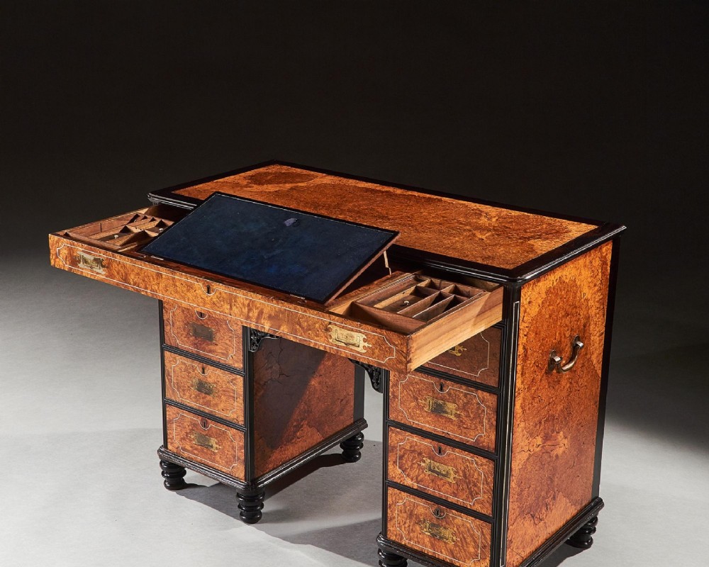 A 19th-century Chinese export kneehole campaign desk crafted from figured amboyna wood with ebony borders and brass carrying handles. View VI