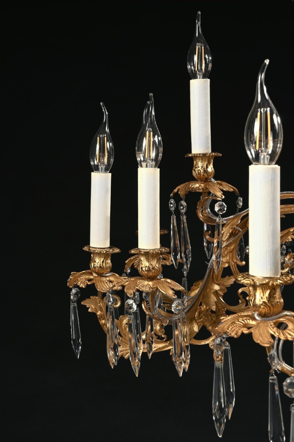A late nineteenth-century Louis XV style gilt bronze chandelier with twenty-five candle lights across two tiers, embellished with cut glass droplets and ornate scrolling metalwork. View V