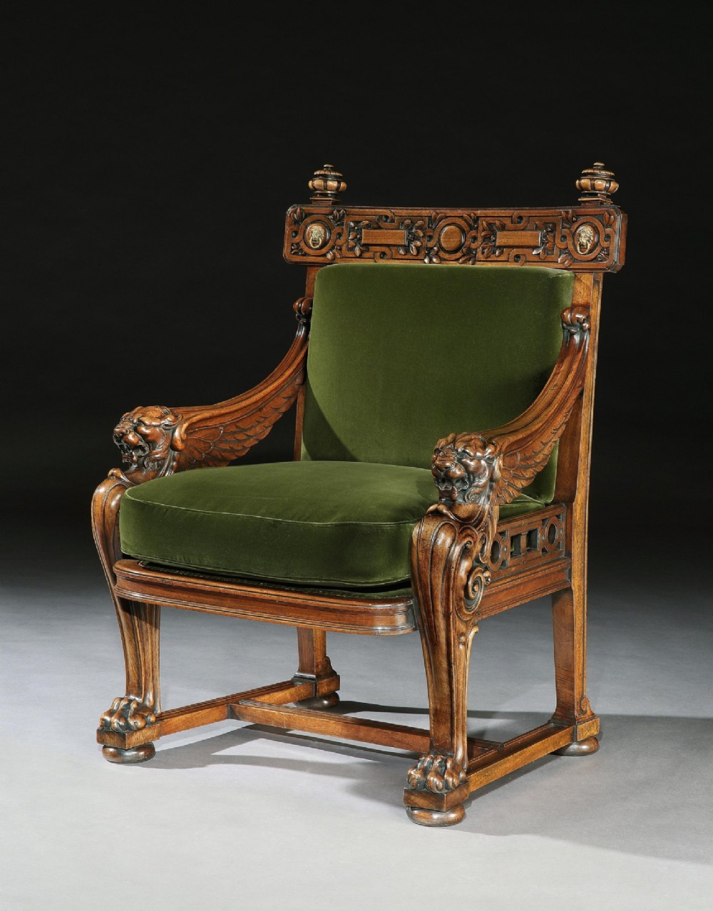 A carved wood armchair with green velvet upholstery, winged lion head armrests, carved claw feet, and a decorated crest rail. View II