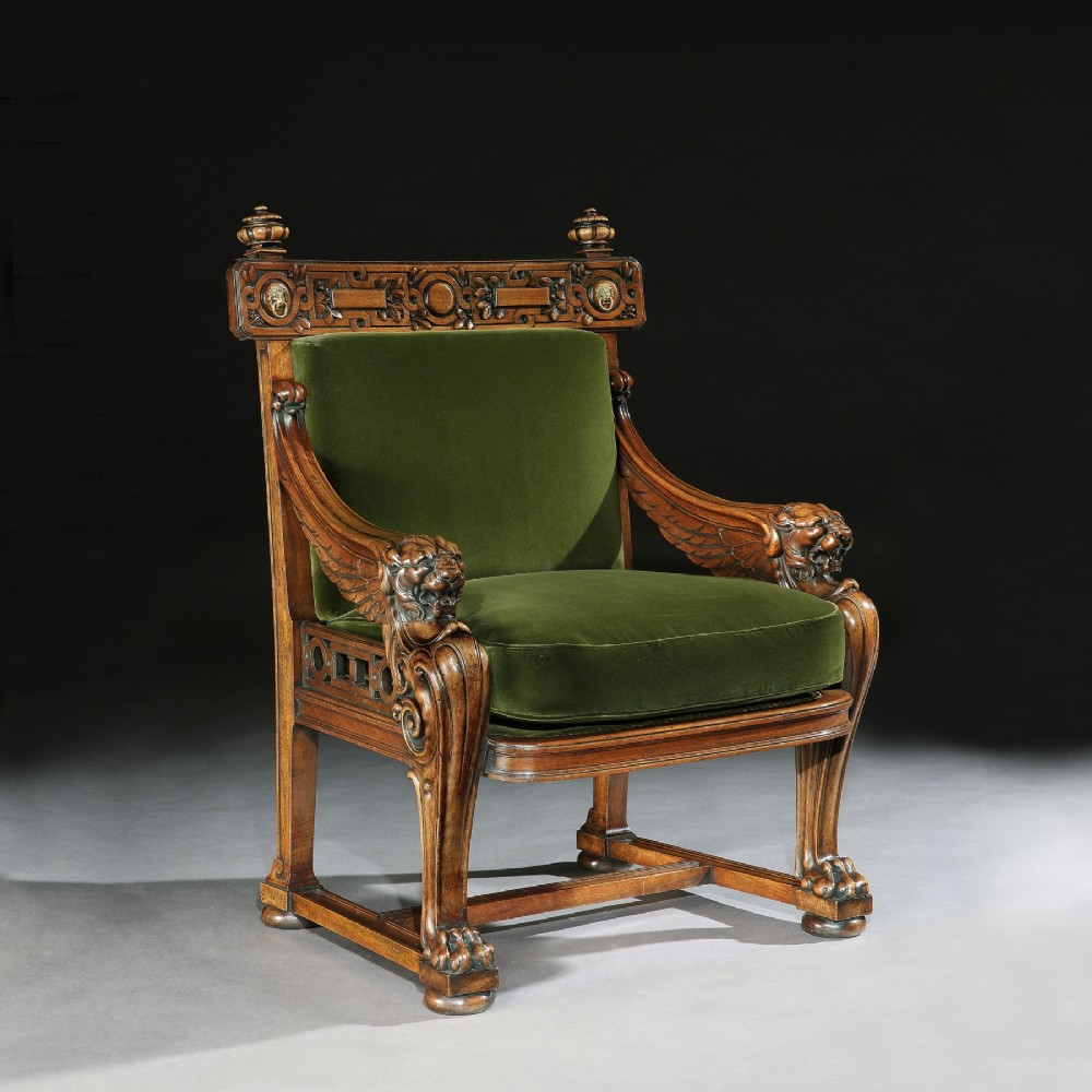 A carved wood armchair with green velvet upholstery, winged lion head armrests, carved claw feet, and a decorated crest rail. View III