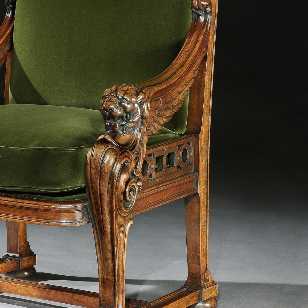 A carved wood armchair with green velvet upholstery, winged lion head armrests, carved claw feet, and a decorated crest rail. View IV