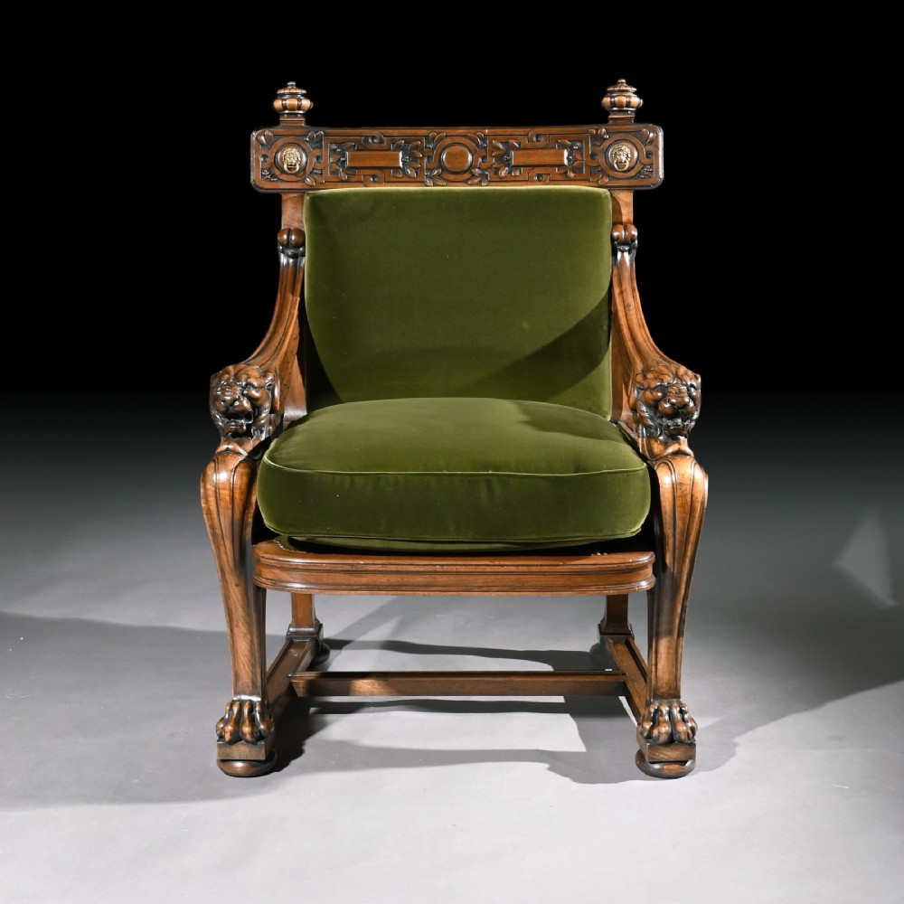 A carved wood armchair with green velvet upholstery, winged lion head armrests, carved claw feet, and a decorated crest rail. View VI