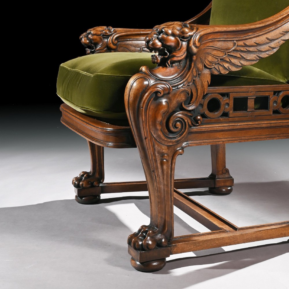 A carved wood armchair with green velvet upholstery, winged lion head armrests, carved claw feet, and a decorated crest rail. View VII