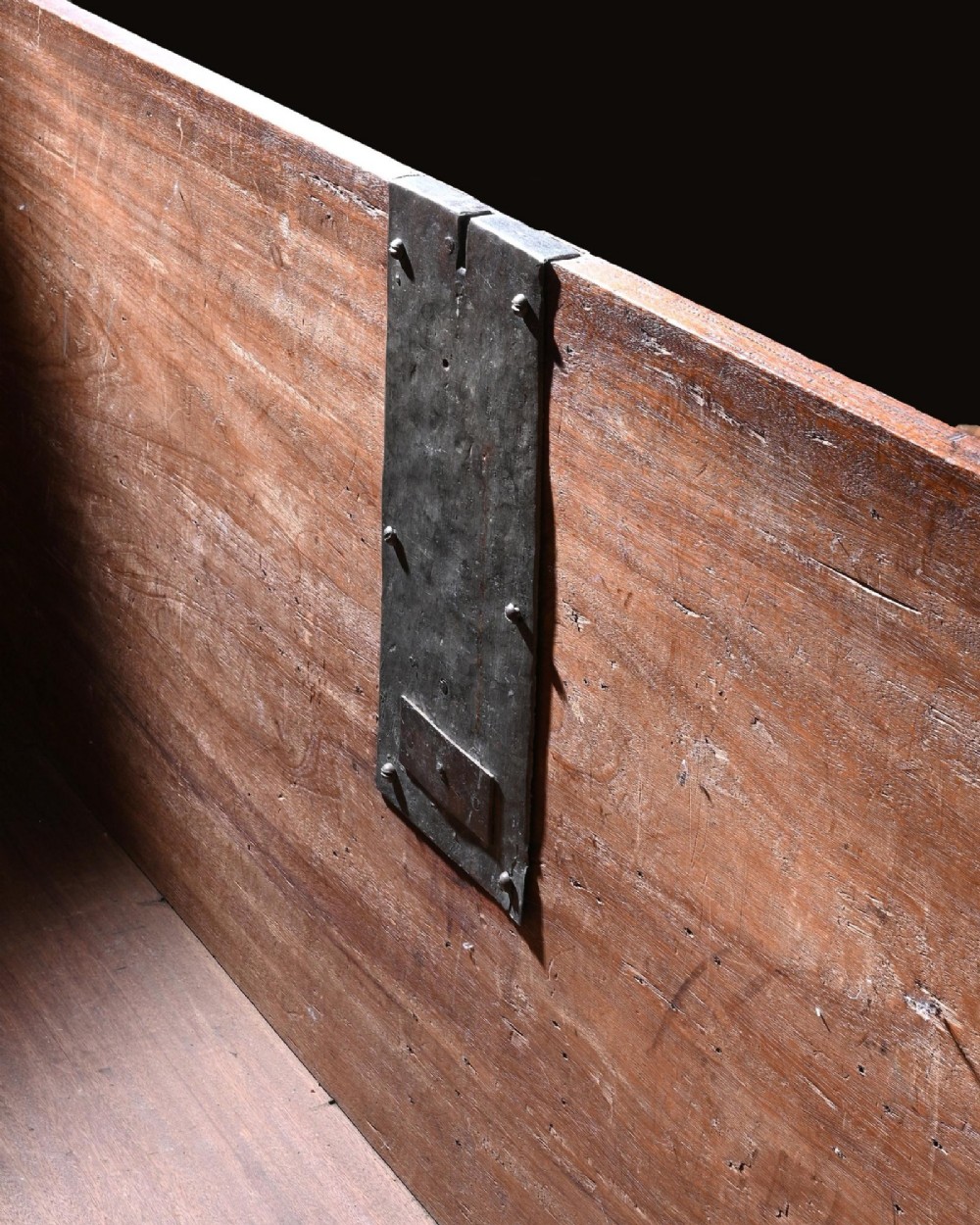 A dark mahogany Portuguese colonial chest featuring three raised diamond-moulded panels with central pierced brass mounts above a row of lower drawers. View VI