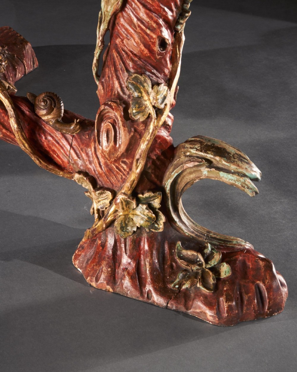 An ornate Italian centre table featuring a sunburst pattern onyx top supported by a sculpted polychrome and gilded wooden frame shaped like grapevine branches. View VI
