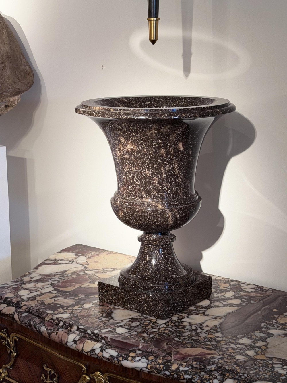 A pair of polished dark brown speckled porphyry stone urns crafted in the classical Campana shape with flared rims and square bases. View VIII