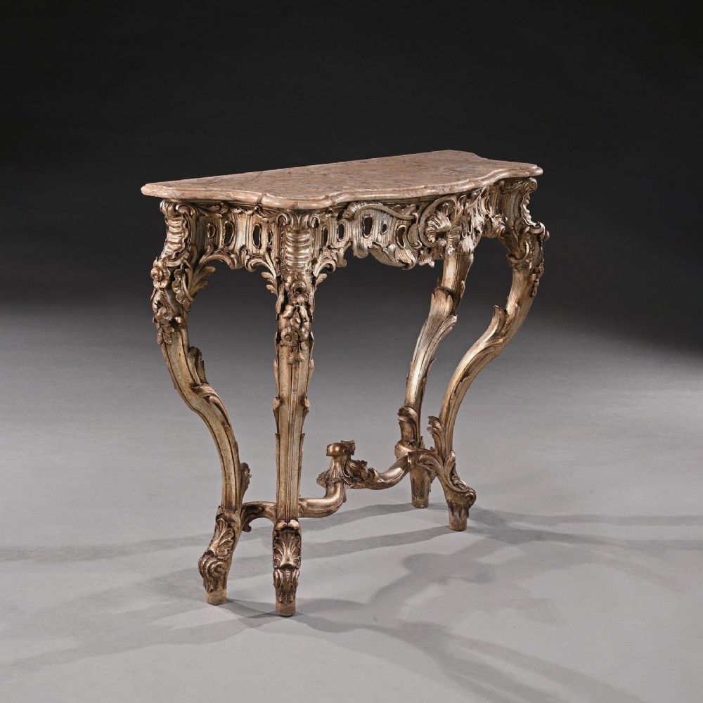 A 19th-century Italian silver gilt console table featuring elaborate Rococo carvings, cabriole legs, a central stretcher, and a contoured marble top. View IV