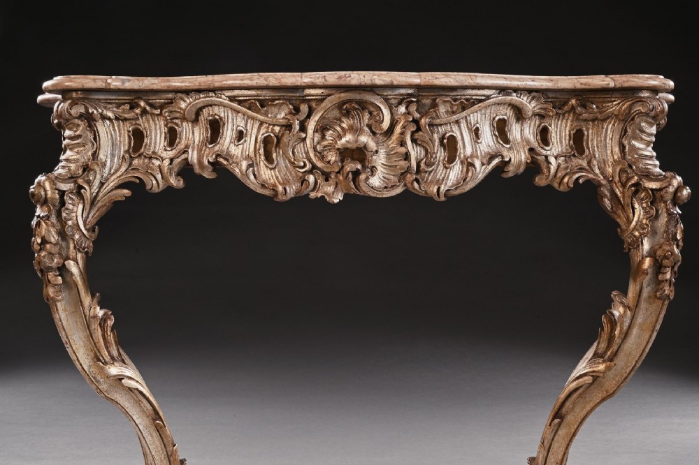 A 19th-century Italian silver gilt console table featuring elaborate Rococo carvings, cabriole legs, a central stretcher, and a contoured marble top. View VI