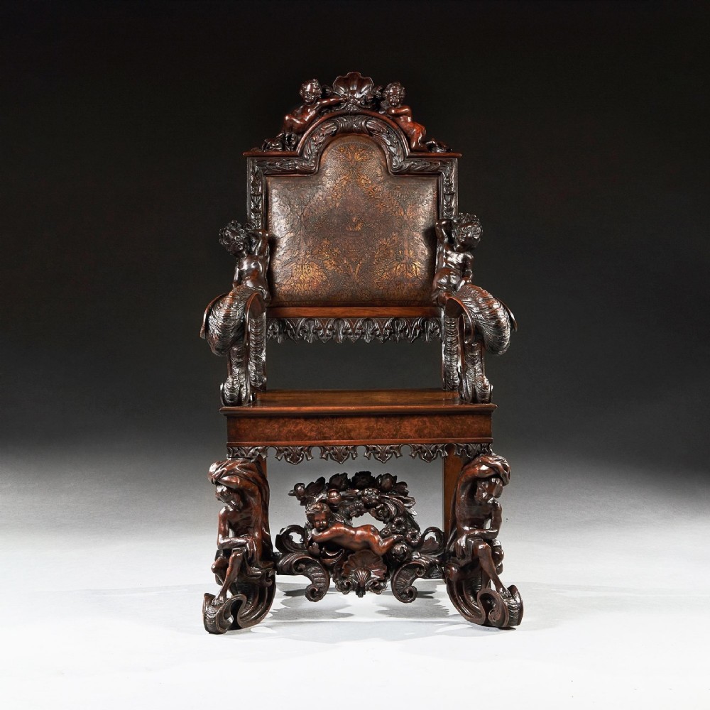 A 19th-century Italian carved walnut armchair featuring elaborate sculptural figural supports and an embossed high backrest. View II