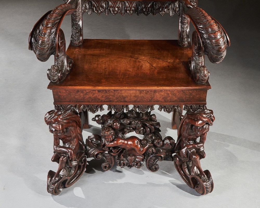A 19th-century Italian carved walnut armchair featuring elaborate sculptural figural supports and an embossed high backrest. View VIII