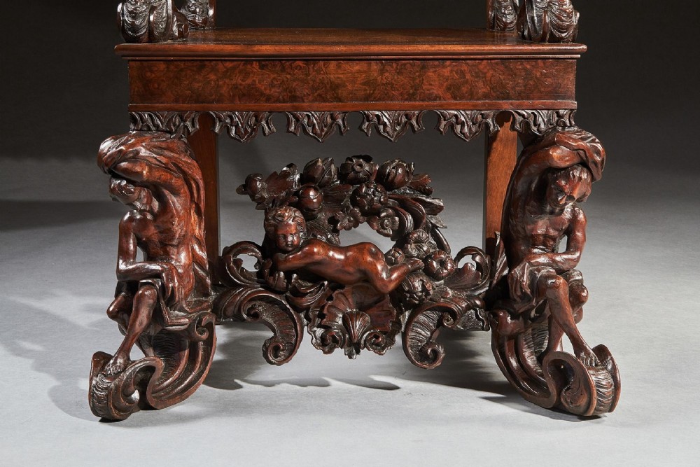 A 19th-century Italian carved walnut armchair featuring elaborate sculptural figural supports and an embossed high backrest. View IX