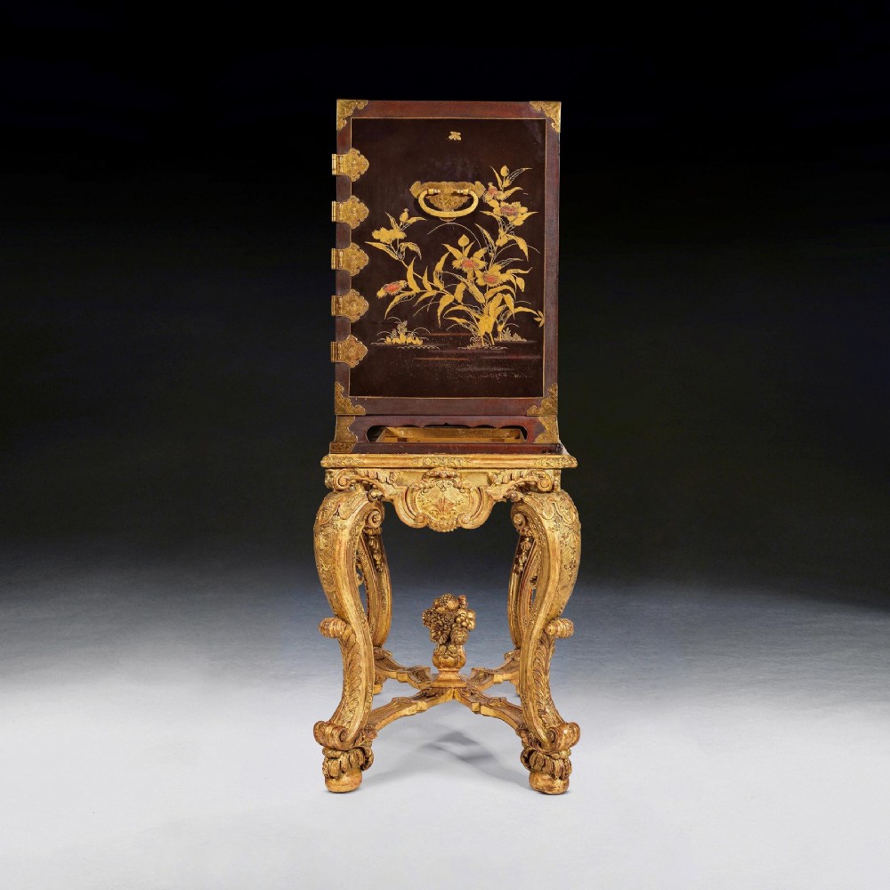 A black Japanese urushi lacquer cabinet decorated with gold landscape scenes and metal corner mounts, supported on a carved French Regence giltwood stand with cabriole legs. View VI