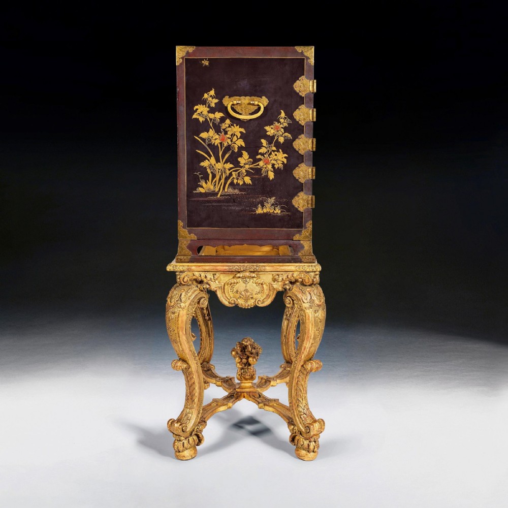 A black Japanese urushi lacquer cabinet decorated with gold landscape scenes and metal corner mounts, supported on a carved French Regence giltwood stand with cabriole legs. View VII