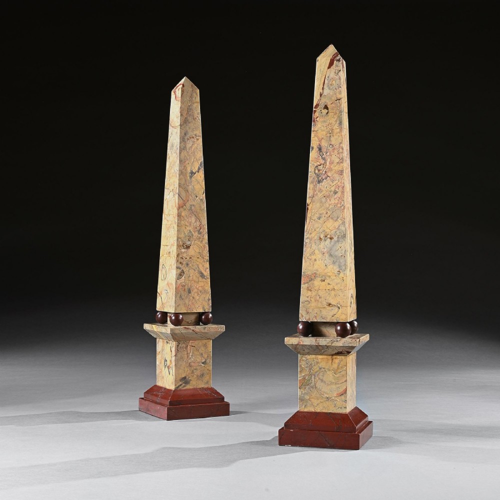 A pair of tall, veined marble obelisks carved from Portasanta and Rosso Antico marble with polished spherical details on tiered square bases. View III