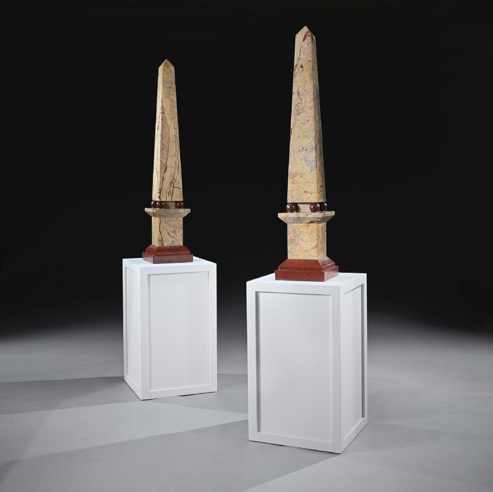 A pair of tall, veined marble obelisks carved from Portasanta and Rosso Antico marble with polished spherical details on tiered square bases. View VII