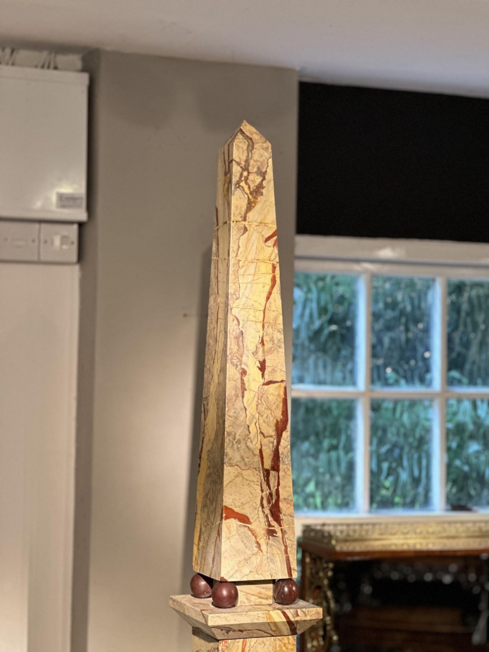 A pair of tall, veined marble obelisks carved from Portasanta and Rosso Antico marble with polished spherical details on tiered square bases. View X