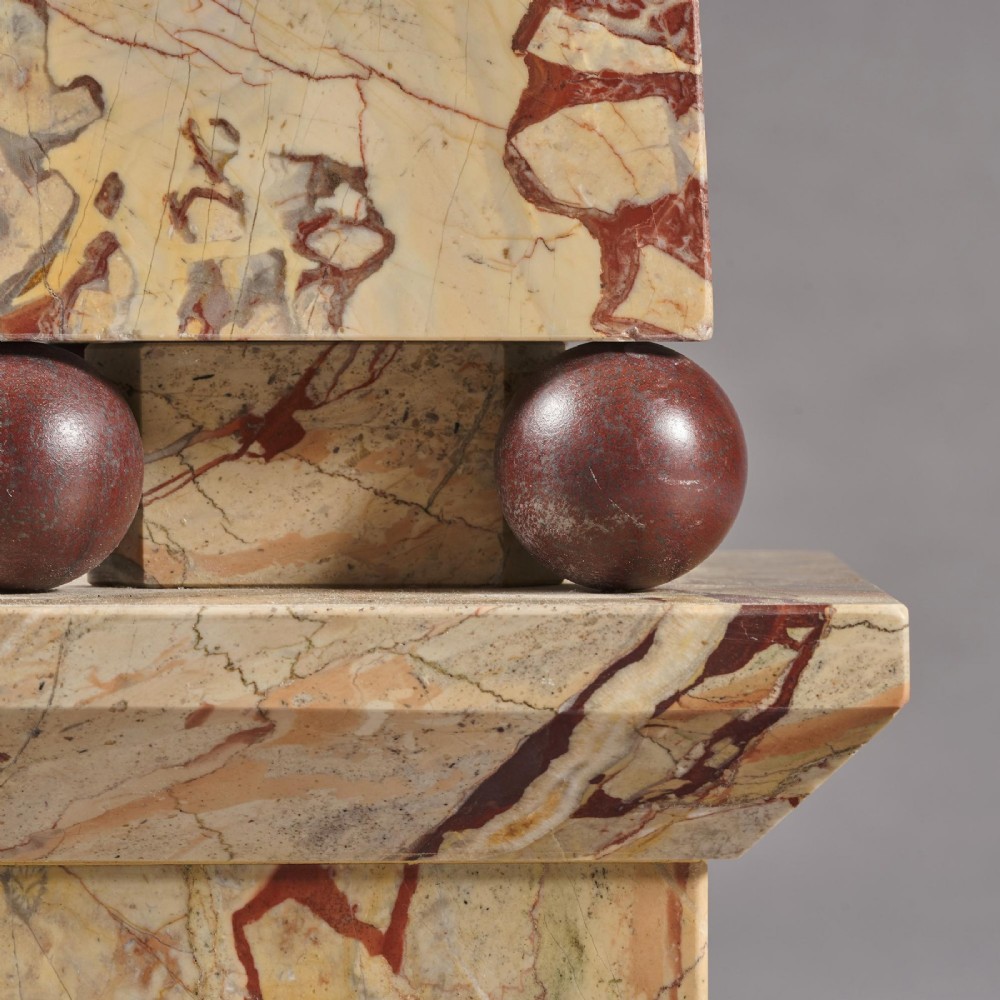 A pair of tall, veined marble obelisks carved from Portasanta and Rosso Antico marble with polished spherical details on tiered square bases. View XIV